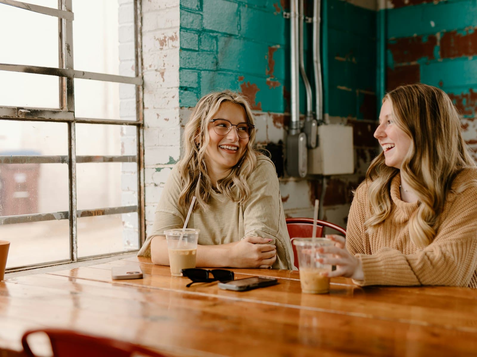 Twee vrouwen in een informeel gesprek met koffie aan tafel