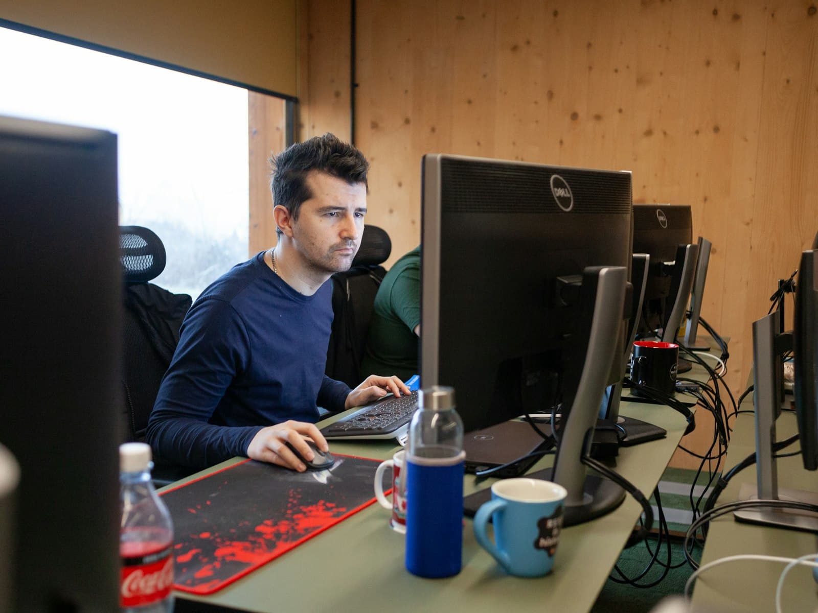 ICT-professional aan de slag achter twee schermen op kantoor